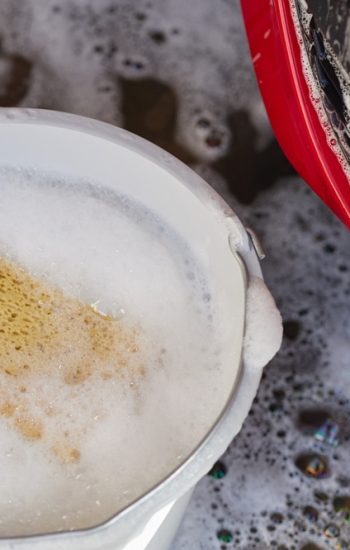 Yellow,Sponge,Soaking,In,Soapy,Water,Inside,Plastic,Bucket,Next